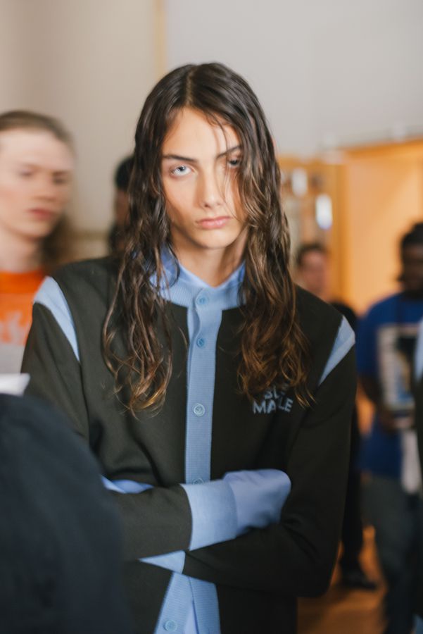 Model backstage with wet hair, arms crossed