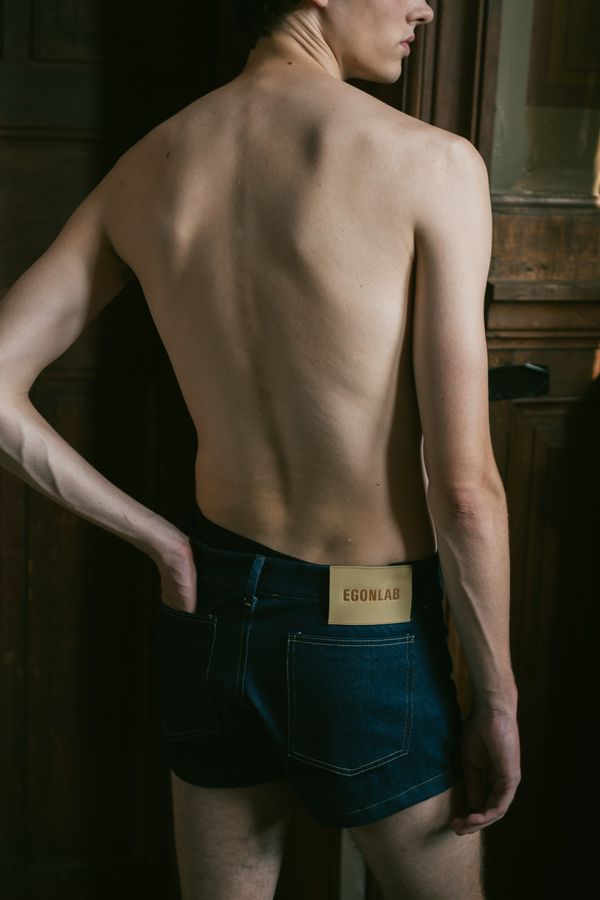 Bare back and denim in window light
