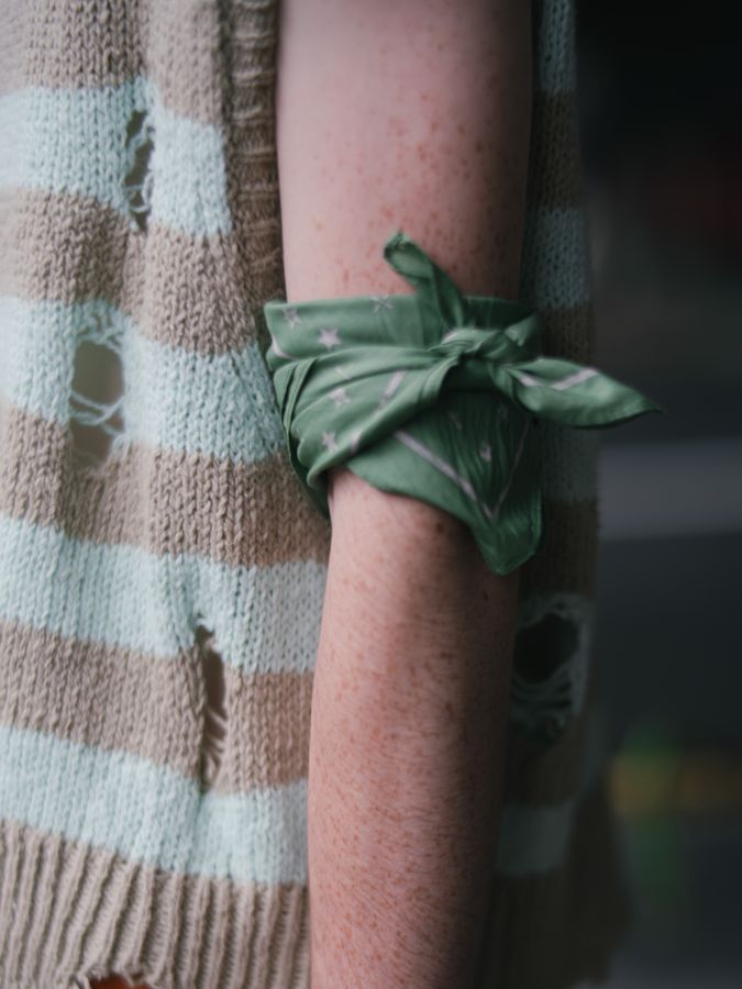 Knit detail with a ribbon tied at the arm