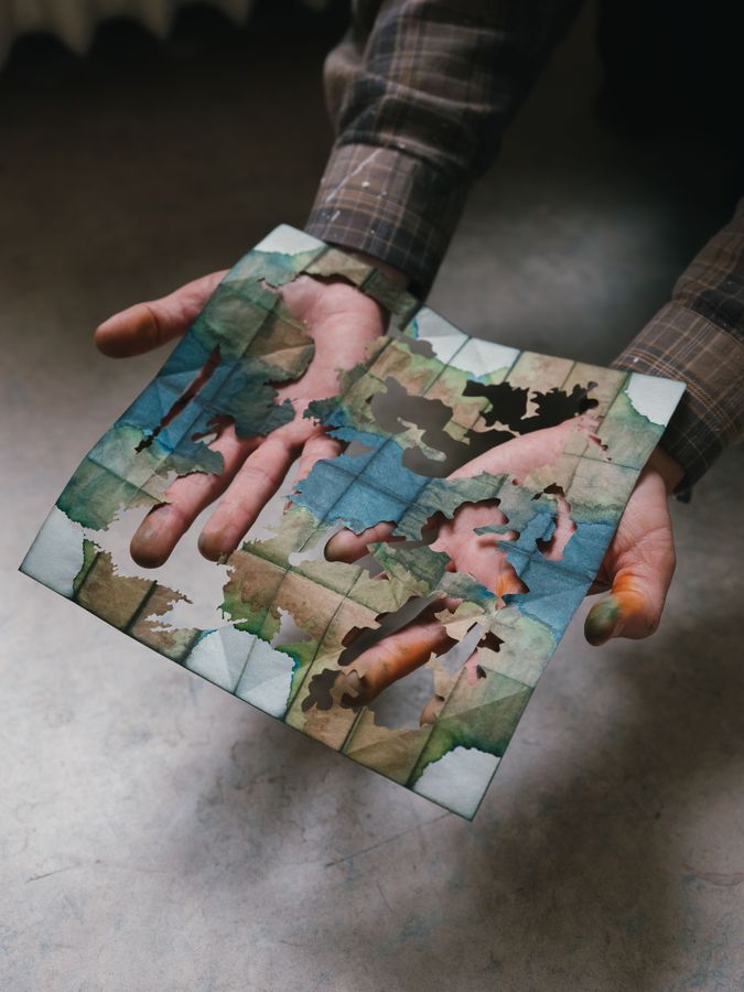 Hands holding a collaged photograph