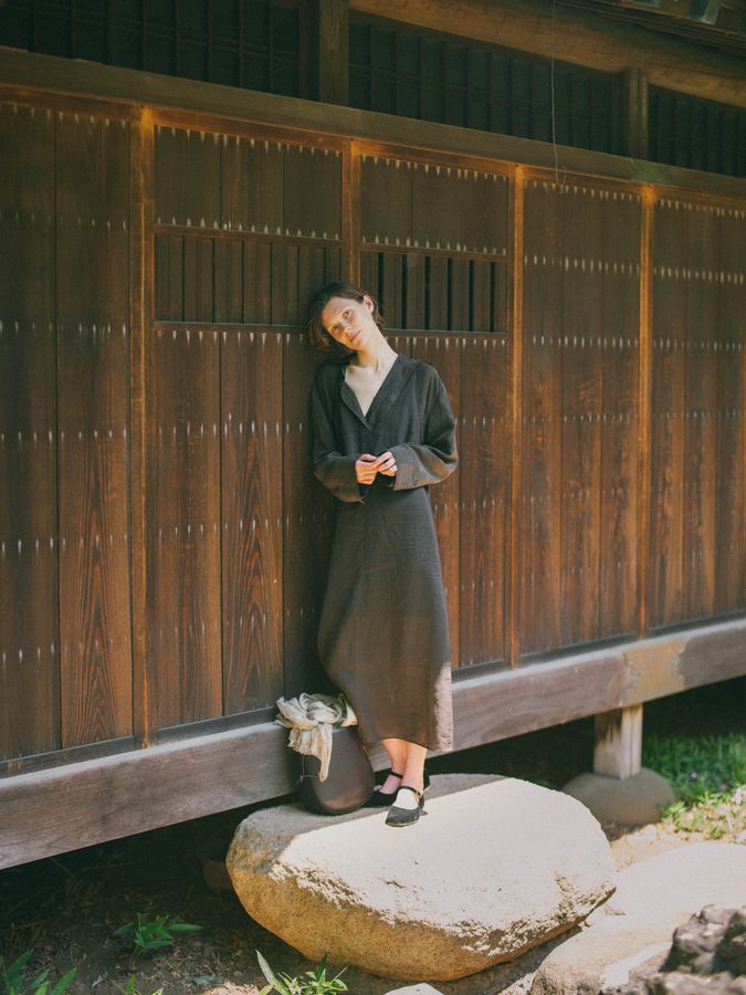 Standing on a stone before a wooden wall