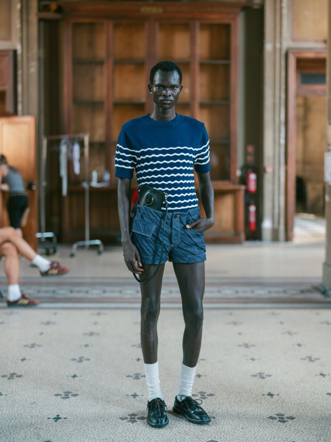 Striped tee and shorts in a tiled hall