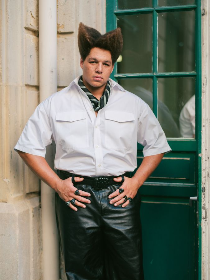 White shirt and leather by a green door