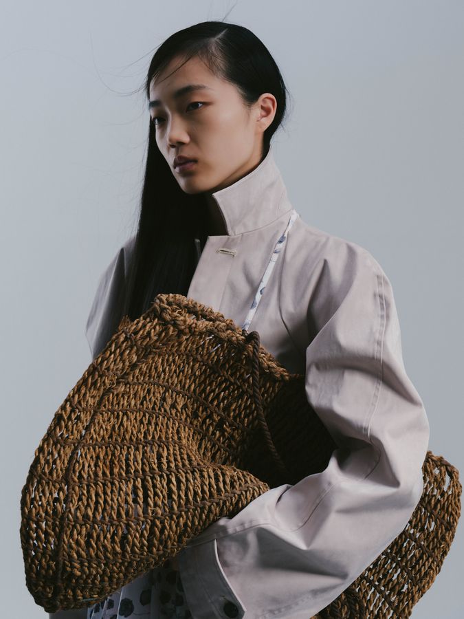 Holding a woven bag in the studio