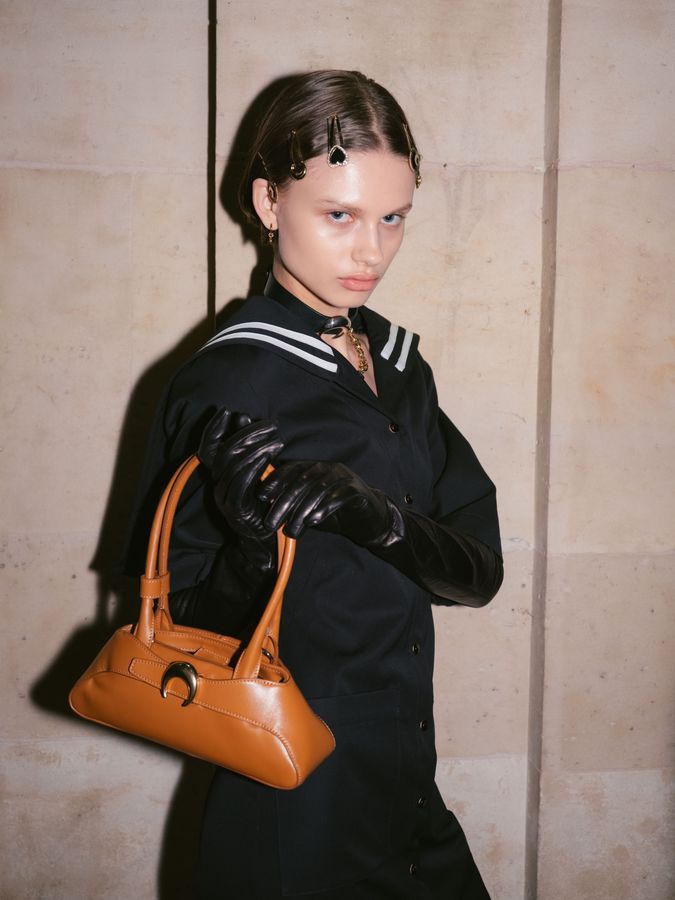 Black dress, gloves and an orange bag